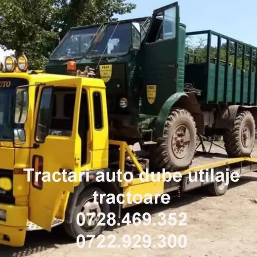 Camion vechi cu remorcă încărcat pe platformă, tractat de o utilitară galbenă