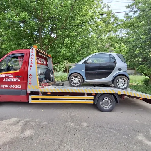 Autoturism mic, model Smart, încărcat pe platforma hidraulică de tractare